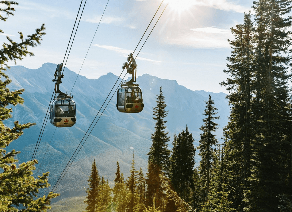 Experience the Banff Gondola: Two cars ascend towards the summit, offering panoramic mountain views